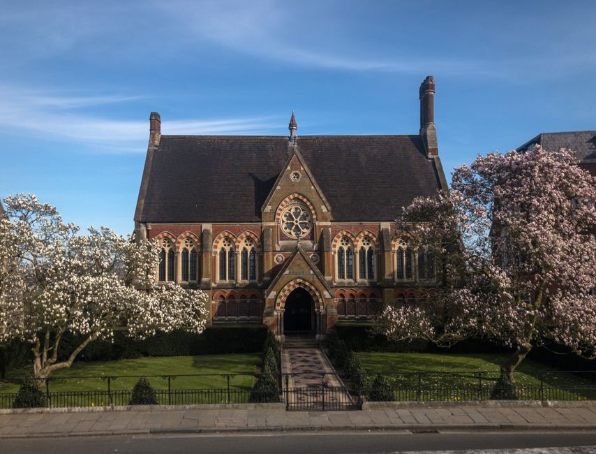 Stunning view of the historic Vaughan Library at Harrow School with blossoming trees.