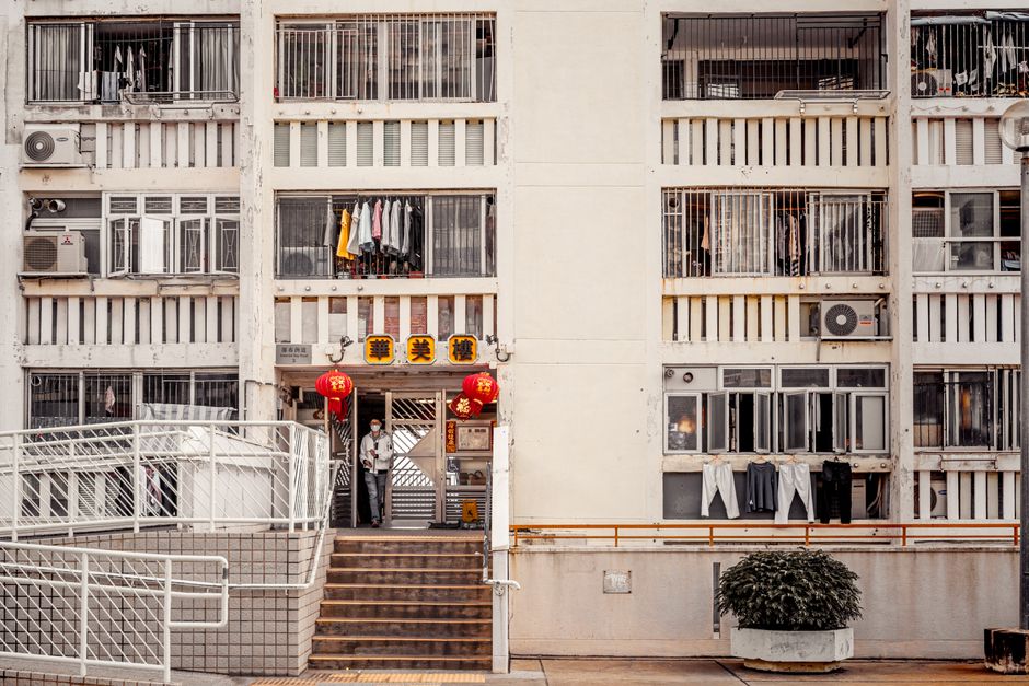 Exterior view of a residential building in Hong Kong with open windows and laundry.