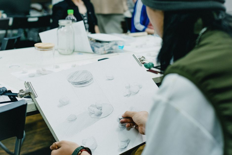 Students sketching a still life arrangement in a Tokyo art class, capturing creative still life moments.