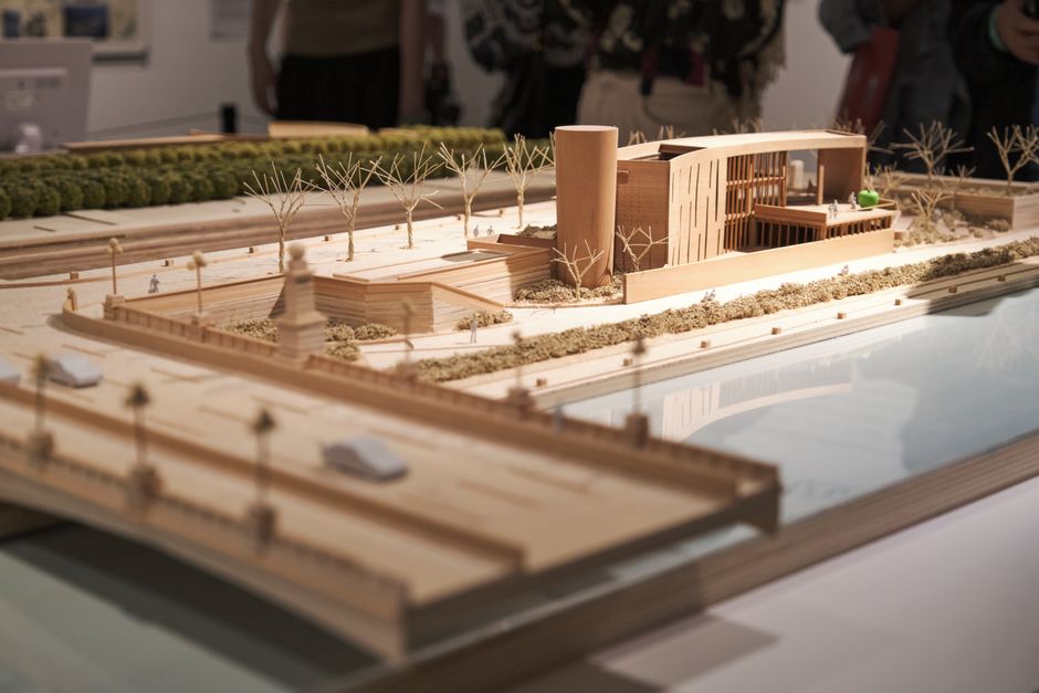 Detailed wooden architectural scale model displayed in an exhibition environment.
